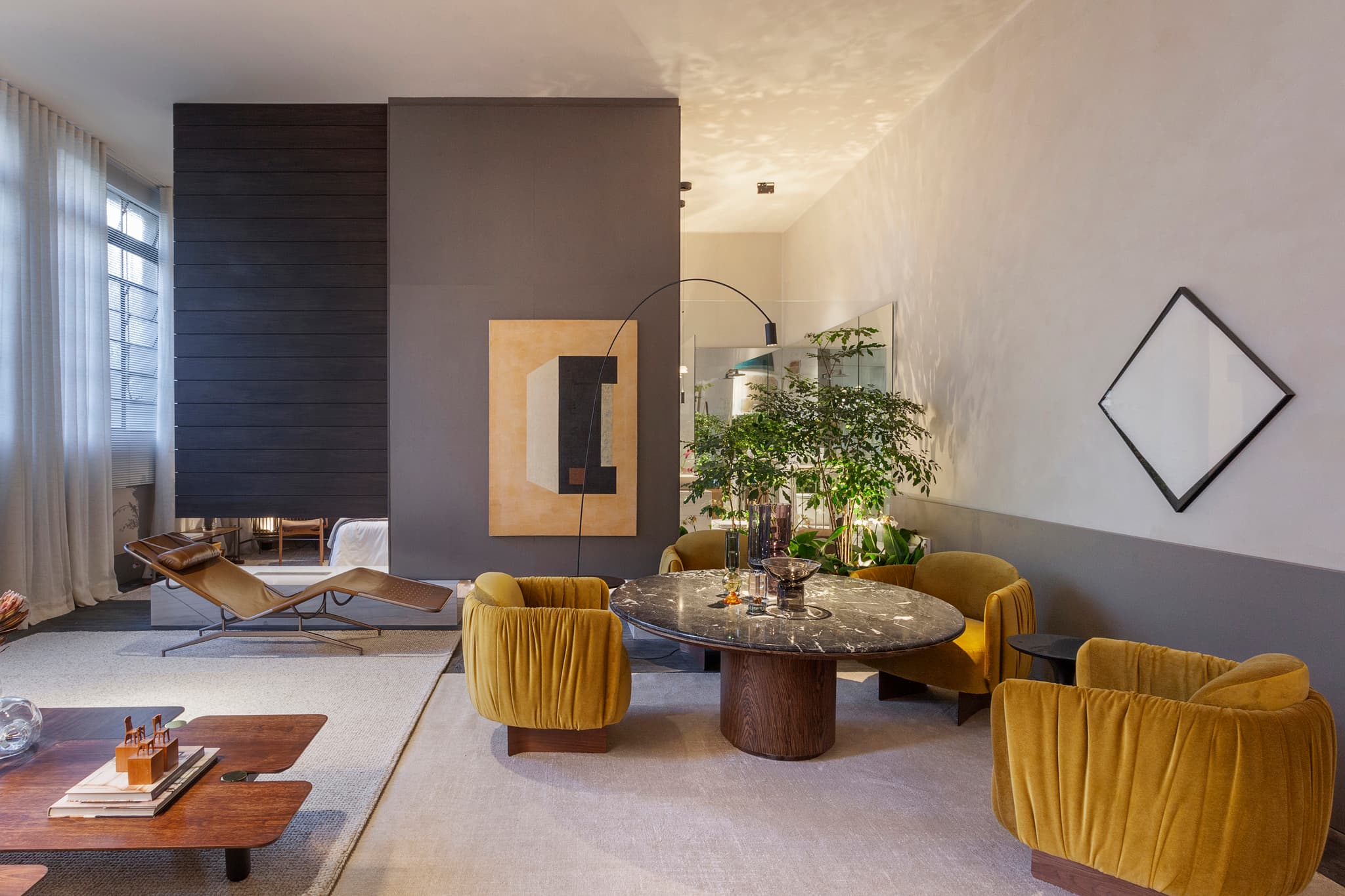 Sala de estar sofisticada com poltronas amarelas e mesa de mármore