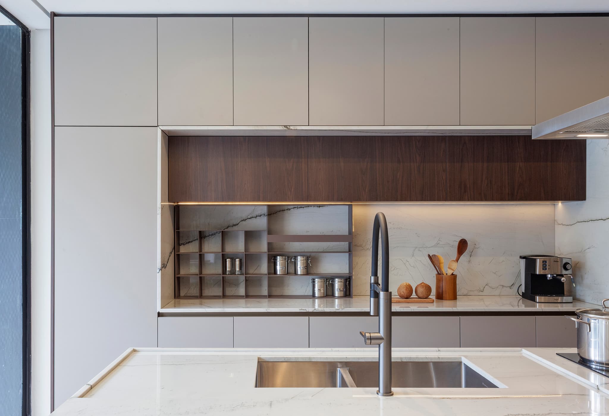 Detalhe de cozinha planejada com bancada em mármore e acabamentos em madeira